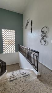 a staircase in a house with two windows at Hotel Class Colonial in Santo Domingo