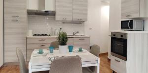 a kitchen with a table with chairs and a microwave at Appartamento storico in zona Barberini in Rome