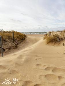 a dirt road leading to the ocean on a beach at Baltic Zen - Apartament in Hel