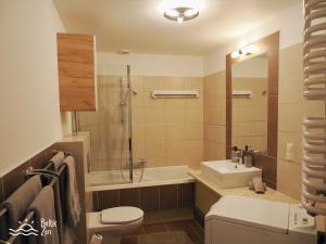 a bathroom with a toilet and a sink and a shower at Baltic Zen - Apartament in Hel