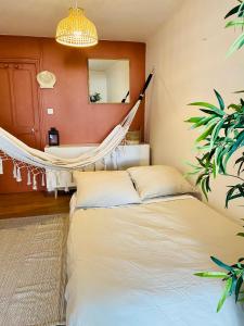 a hammock in a bedroom with a bed and a mirror at Maisonnette climatisée à 35m de la plage de La Capte Hyères in Hyères