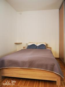 a bedroom with a large bed with blue pillows at Baltic Zen - Apartament in Hel