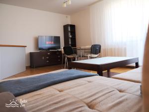 een slaapkamer met een bed en een tafel en een televisie bij Baltic Zen - Apartament in Hel