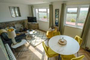a living room with a table and chairs at Priory Bay Escapes - Matahari in Tenby