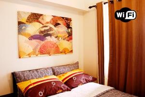 een slaapkamer met een bed en een schilderij aan de muur bij DRAMATIC SUNSET VIEW 1BR front CCP near NAIA in Manilla