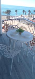 una mesa blanca y sillas en un balcón con vistas a la playa en Brisa marina 3, en Benalmádena