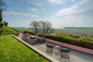 a patio with two chairs and a table at Priory Bay Escapes - Matahari in Tenby