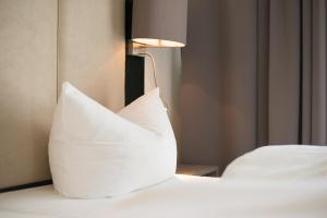 a pillow sitting on a bed next to a lamp at Goethe Conference Hotel by Trip Inn in Frankfurt