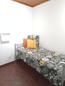 um quarto com uma cama com um edredão preto e amarelo em VillasMC no Alpalhão