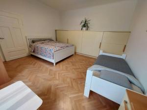 a bedroom with two beds and a wooden floor at Apartment Bezigrad in Ljubljana