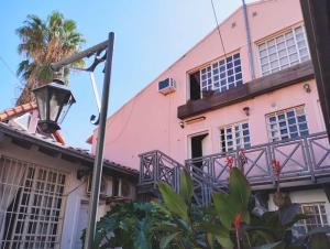 a pink building with a balcony and a street light at Quiet luxury loft in Mendoza