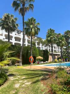 a resort with a swimming pool and palm trees at Altos De La Quinta II Apartment Marbella in Marbella