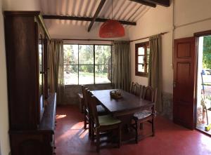 ein Esszimmer mit einem Holztisch und Stühlen in der Unterkunft La Linda de la Aldea Serrana in La Falda + 39 Fotos