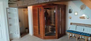 einem Holzschrank mit Glastüren in einem Zimmer in der Unterkunft Chambre d'hôtes Bien-être 