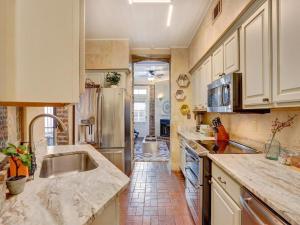 a kitchen with a sink and a refrigerator at The Lyons House - Luxe Historical Home - Parking Included in Savannah