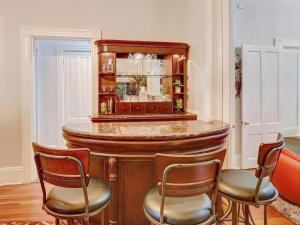 a bar in a room with three chairs and a table at The Lyons House - Luxe Historical Home - Parking Included in Savannah