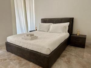 - un lit avec un cadre noir et des oreillers blancs dans l'établissement Magic Place Bergamo! Appartamento elegante nel cuore di Bergamo, à Bergame