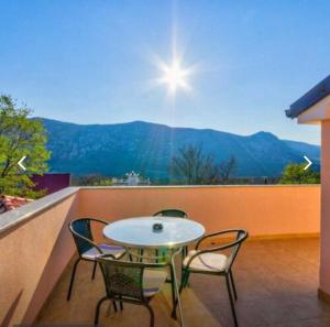 a patio with a table and chairs on a balcony at Crikvenica Villa Vanja in Kostelj
