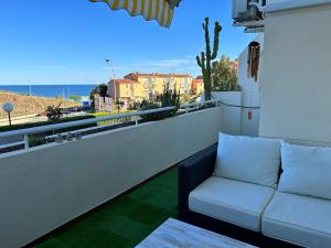 un sofá en un balcón con vistas al océano en FUENGIROLA Castillo Malaga PARADAISE 3, en Fuengirola