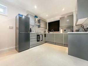 eine Küche mit einem Kühlschrank aus Edelstahl in der Unterkunft New Cosy Luxury 3 Bedroom House in Battersea London in London