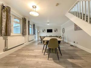 ein Esszimmer mit einem Tisch, Stühlen und einer Treppe in der Unterkunft New Cosy Luxury 3 Bedroom House in Battersea London in London