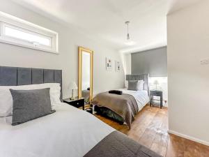 1 Schlafzimmer mit 2 Betten und einem Spiegel in der Unterkunft New Cosy Luxury 3 Bedroom House in Battersea London in London
