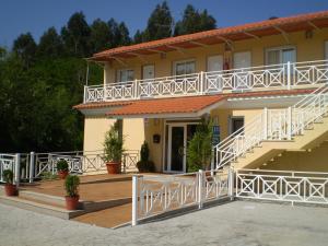 uma casa com grades brancas e escadas em frente em Sun Galicia Hotel y Apartamentos em Sanxenxo