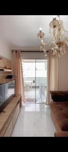 Apartamento novo Gran Safira في ايتابيما: غرفة معيشة مع أريكة وثريا