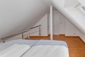 a white bed in a room with a staircase at Ferienwohnung Julia - klimatisiert in Wolken