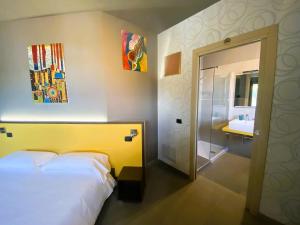 a bedroom with a bed and a bathroom with a sink at Vela di Soleville camere con e senza vista lago con ristorante & pizzeria in Sale Marasino