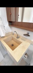 a wooden sink in a kitchen with a mirror at Apartamento novo Gran Safira in Itapema
