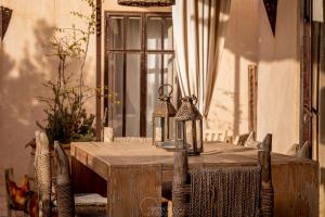 drewniany stół z dwoma latarniami na górze w obiekcie Dar Alya Essaouira Maison et table d'hôtes w mieście Ghazoua