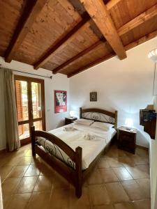 1 dormitorio con 1 cama grande y techo de madera en CAPO CODA CAVALLO VILLA SALINEDDA GIARDINO VISTA MARE, en Capo Coda Cavallo