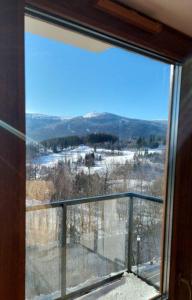 um quarto com uma janela com vista para uma montanha de neve em Green Park Resort - Widokowy D14 z dostępem do Basenu, Sauny i Jacuzzi em Szklarska Poręba