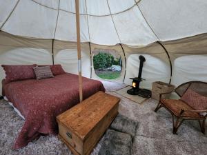 1 dormitorio con 1 cama en una tienda de campaña en Possum Lodge, en Manapouri