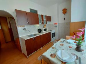 una cocina con una mesa con platos. en 2-iz. byt v tichej lokalite s bezplatným parkovaním en Liptovský Hrádok