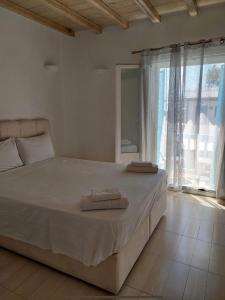 a bedroom with a large bed with two towels on it at Mykonos efis maisonette in Mikonos
