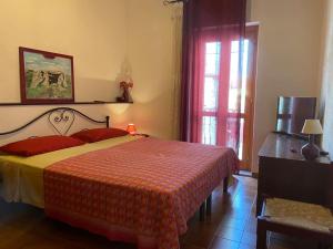 um quarto com uma cama com um cobertor vermelho e amarelo em Flat Tempio Pausania near Costa Smeralda em Tempio Pausania