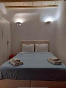 ミコノス・シティにあるMykonos efis maisonetteのベッドルーム1室(ベッド1台、タオル2枚付)