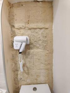 a bathroom with a white hair dryer attached to a wall at Cove 532 by Savynomad Harbour Residences wow View in Valletta