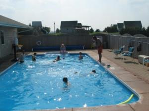 un grupo de personas jugando en una piscina en Swept Away Cottages, en Cavendish