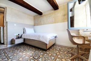 una camera con letto, finestra e sedia di Cove 532 by Savynomad Harbour Residences wow View a La Valletta