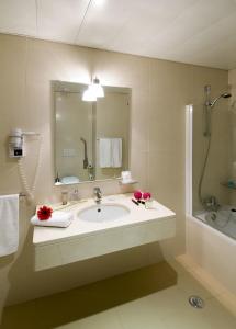 a bathroom with a sink and a shower and a mirror at Coração de Fatima Boutique Hotel in Fátima