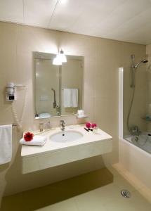 W łazience znajduje się umywalka, prysznic i lustro. w obiekcie Coração de Fatima Boutique Hotel w Fatimie