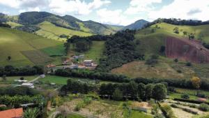 a view of a green hillside with houses and trees at Recanto das Videiras in Maria da Fé