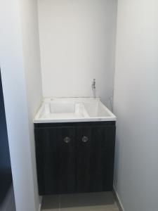 La salle de bains est pourvue d'un lavabo blanc. dans l'établissement Lujoso Apartamento Cerca al Lago Sochagota en Paipa, à Paipa