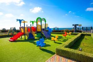 um parque com parque infantil com escorrega em Garden Bay - Appartement en bord de mer em Tamaris