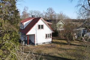 un granero blanco con techo rojo en un campo en Lantlig villa i Ljungbyhed, en Ljungbyhed