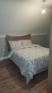 1 dormitorio con 1 cama con edredón blanco en Meadow View, en Moneymore