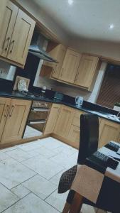 a kitchen with wooden cabinets and a tile floor at Meadow View in Moneymore